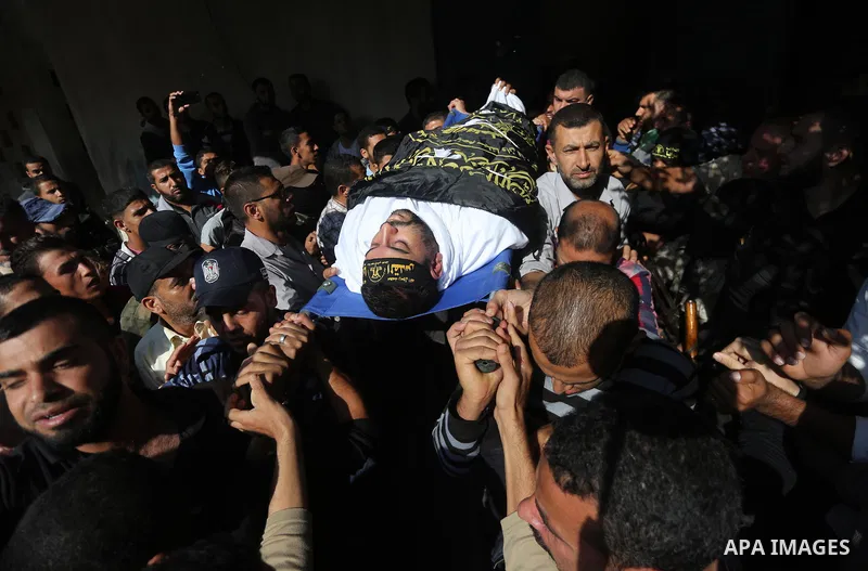 Palestinian mourners carry the body of one of the Palestinians killed in an Israeli operation to blow up a tunnel stretching from the Gaza Strip into Israel during their funeral in Bureij refugee camp in central Gaza Str...
