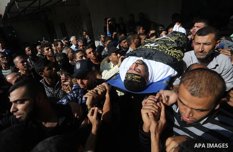 Palestinian mourners carry the body of one of the Palestinians killed in an Israeli operation to blow up a tunnel stretching from the Gaza Strip into Israel during their funeral in Bureij refugee camp in central Gaza Str...