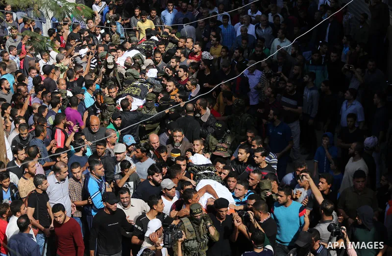 Palestinian mourners carry the body of one of the Palestinians killed in an Israeli operation to blow up a tunnel stretching from the Gaza Strip into Israel during their funeral in Bureij refugee camp in central Gaza Str...