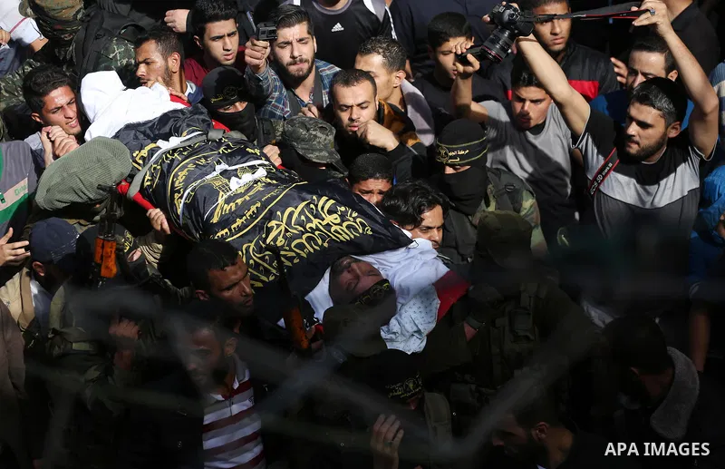 Palestinian mourners carry the body of one of the Palestinians killed in an Israeli operation to blow up a tunnel stretching from the Gaza Strip into Israel during their funeral in Bureij refugee camp in central Gaza Str...
