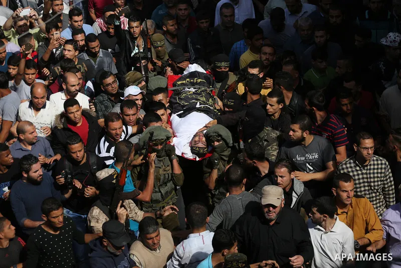 Palestinian mourners carry the body of one of the Palestinians killed in an Israeli operation to blow up a tunnel stretching from the Gaza Strip into Israel during their funeral in Bureij refugee camp in central Gaza Str...