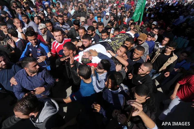 Palestinian mourners carry the body of one of the Palestinians killed in an Israeli operation to blow up a tunnel stretching from the Gaza Strip into Israel during their funeral in Bureij refugee camp in central Gaza Str...
