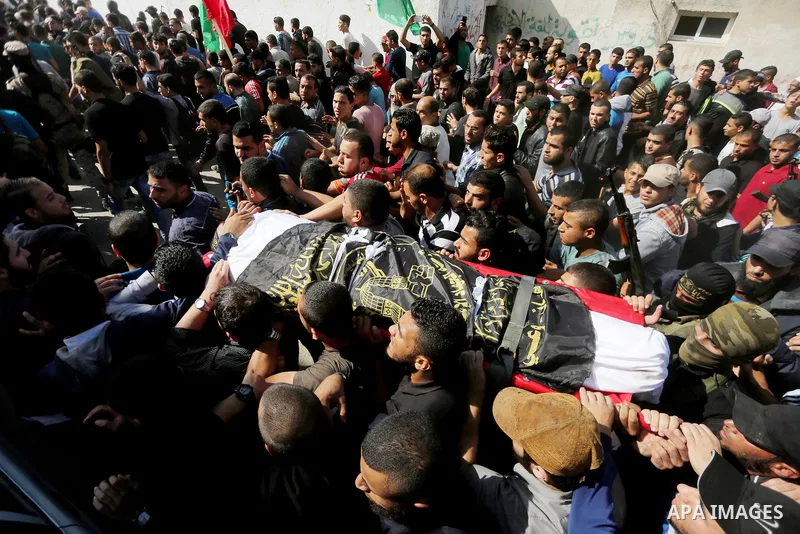 Palestinian mourners carry the body of one of the Palestinians killed in an Israeli operation to blow up a tunnel stretching from the Gaza Strip into Israel during their funeral in Bureij refugee camp in central Gaza Str...