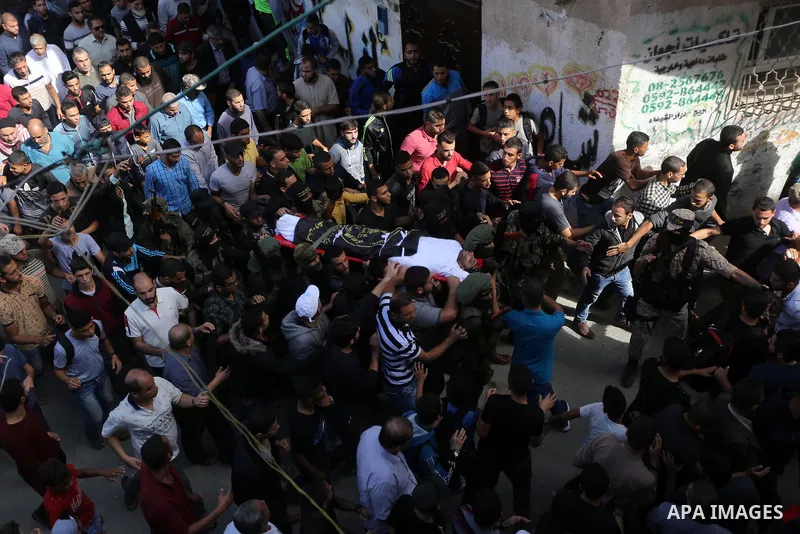 Palestinian mourners carry the body of one of the Palestinians killed in an Israeli operation to blow up a tunnel stretching from the Gaza Strip into Israel during their funeral in Bureij refugee camp in central Gaza Str...