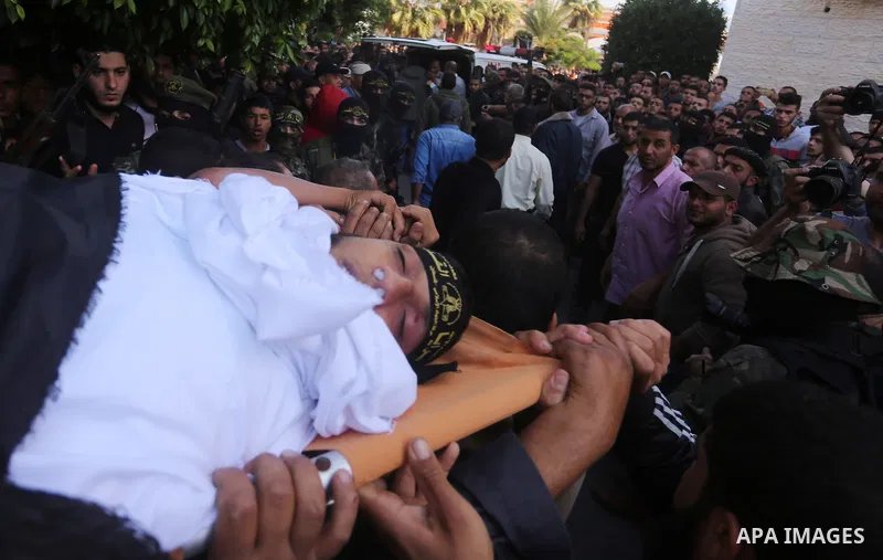 Palestinian mourners carry the body of one of the Palestinians killed in an Israeli operation to blow up a tunnel stretching from the Gaza Strip into Israel during their funeral in Bureij refugee camp in central Gaza Str...