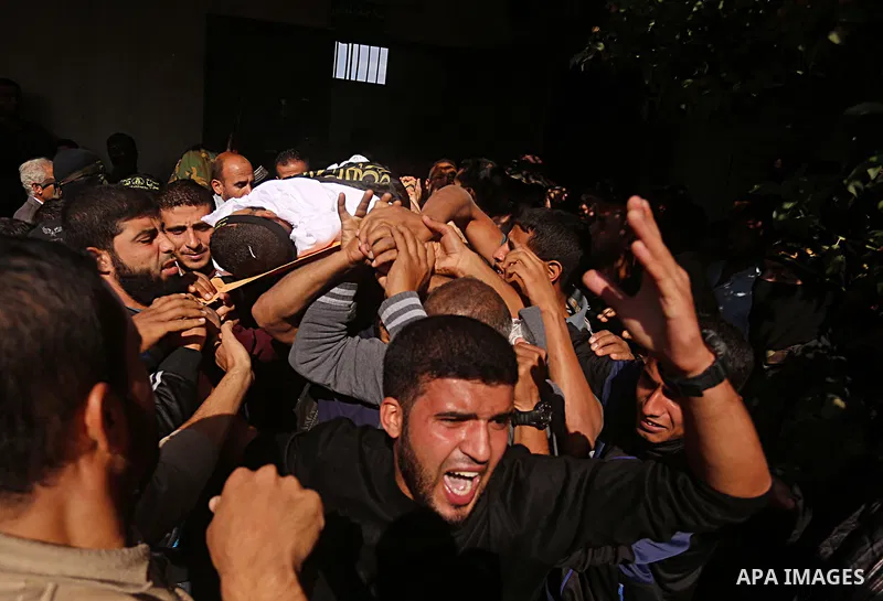 Palestinian mourners carry the body of one of the Palestinians killed in an Israeli operation to blow up a tunnel stretching from the Gaza Strip into Israel during their funeral in Bureij refugee camp in central Gaza Str...