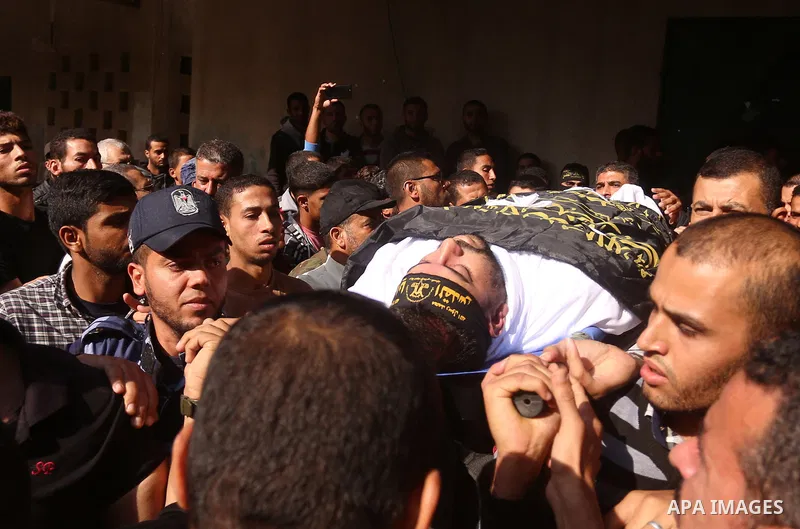 Palestinian mourners carry the body of Hassan Abu Hassanin in Bureij refugee camp in central Gaza Strip on October 31, 2017, during the funeral of Palestinians who were killed the previous day in an Israeli operation to...
