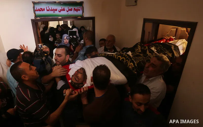 Palestinian mourners carry the body of Hassan Abu Hassanin in Bureij refugee camp in central Gaza Strip on October 31, 2017, during the funeral of Palestinians who were killed the previous day in an Israeli operation to...