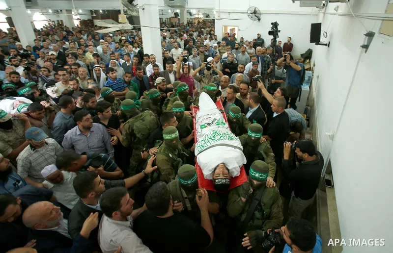Palestinian mourners and fighters from the Ezzedine al-Qassam Brigades, the armed wing of the Palestinian Hamas movement, carry the body of 22-year-old Mohammed Alagha in Khan Yunis, in the southern Gaza Strip, on Octobe...