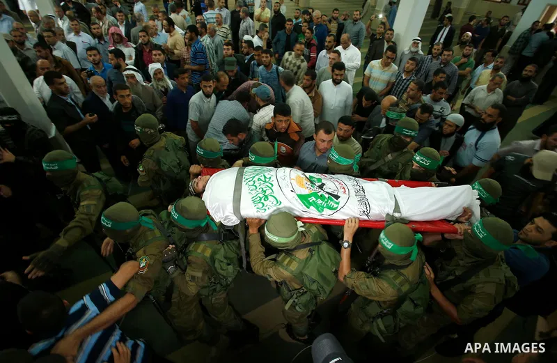 Palestinian mourners and fighters from the Ezzedine al-Qassam Brigades, the armed wing of the Palestinian Hamas movement, carry the body of 22-year-old Mohammed Alagha in Khan Yunis, in the southern Gaza Strip, on Octobe...