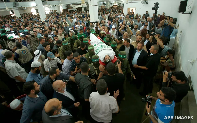 Palestinian mourners and fighters from the Ezzedine al-Qassam Brigades, the armed wing of the Palestinian Hamas movement, carry the body of 22-year-old Mohammed Alagha in Khan Yunis, in the southern Gaza Strip, on Octobe...
