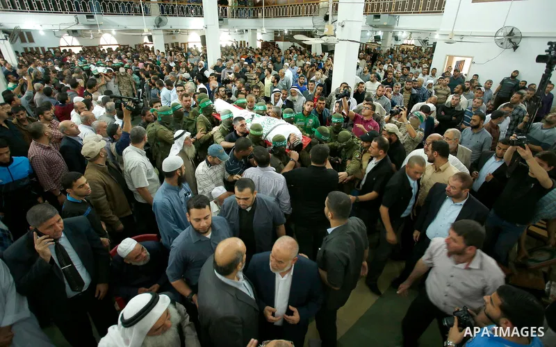 Palestinian mourners and fighters from the Ezzedine al-Qassam Brigades, the armed wing of the Palestinian Hamas movement, carry the body of 22-year-old Mohammed Alagha in Khan Yunis, in the southern Gaza Strip, on Octobe...