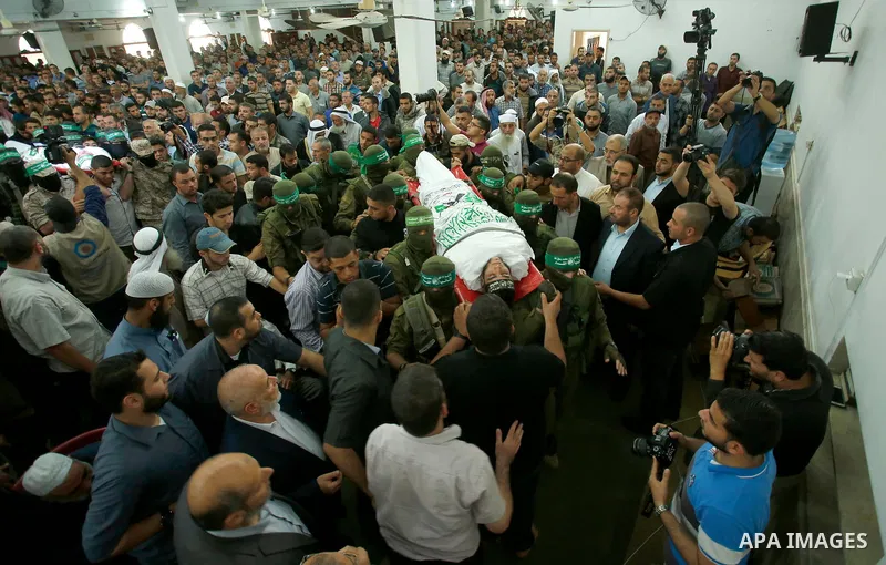 Palestinian mourners and fighters from the Ezzedine al-Qassam Brigades, the armed wing of the Palestinian Hamas movement, carry the body of 22-year-old Mohammed Alagha in Khan Yunis, in the southern Gaza Strip, on Octobe...