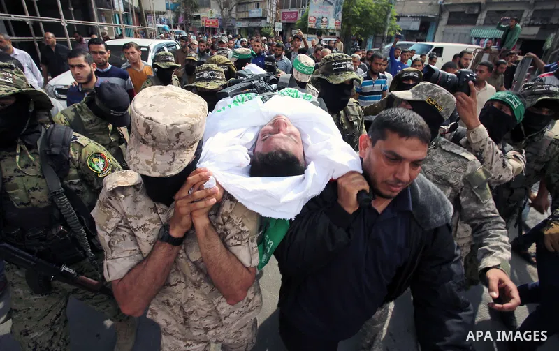 Palestinian mourners and fighters from the Ezzedine al-Qassam Brigades, the armed wing of the Palestinian Hamas movement, carry the body of 30-year-old Mosbah Shabir in Khan Yunis, in the southern Gaza Strip, on October...