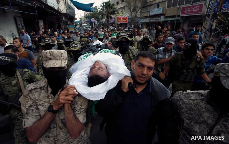 Palestinian mourners and fighters from the Ezzedine al-Qassam Brigades, the armed wing of the Palestinian Hamas movement, carry the body of 30-year-old Mosbah Shabir in Khan Yunis, in the southern Gaza Strip, on October...