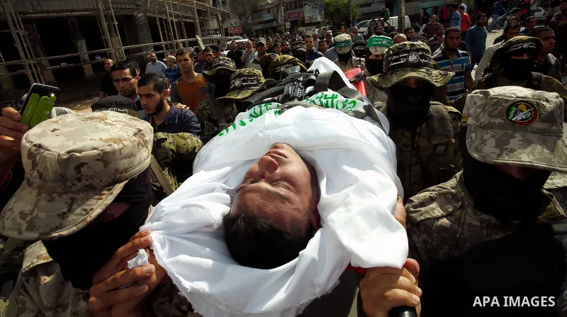 Palestinian mourners and fighters from the Ezzedine al-Qassam Brigades, the armed wing of the Palestinian Hamas movement, carry the body of 30-year-old Mosbah Shabir in Khan Yunis, in the southern Gaza Strip, on October...