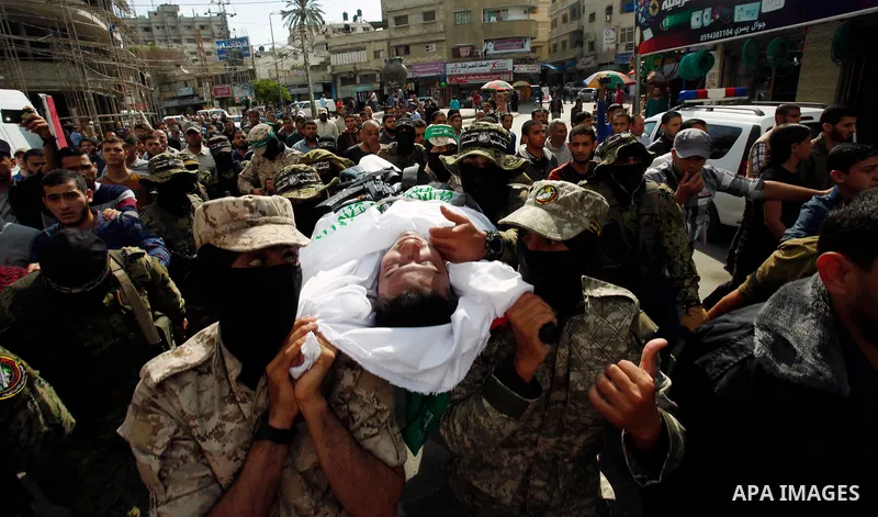 Palestinian mourners and fighters from the Ezzedine al-Qassam Brigades, the armed wing of the Palestinian Hamas movement, carry the body of 30-year-old Mosbah Shabir in Khan Yunis, in the southern Gaza Strip, on October...