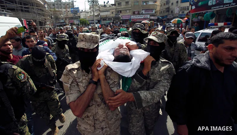 Palestinian mourners and fighters from the Ezzedine al-Qassam Brigades, the armed wing of the Palestinian Hamas movement, carry the body of 30-year-old Mosbah Shabir in Khan Yunis, in the southern Gaza Strip, on October...