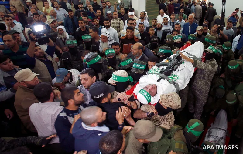 Palestinian mourners and fighters from the Ezzedine al-Qassam Brigades, the armed wing of the Palestinian Hamas movement, carry the body of 30-year-old Mosbah Shabir in Khan Yunis, in the southern Gaza Strip, on October...