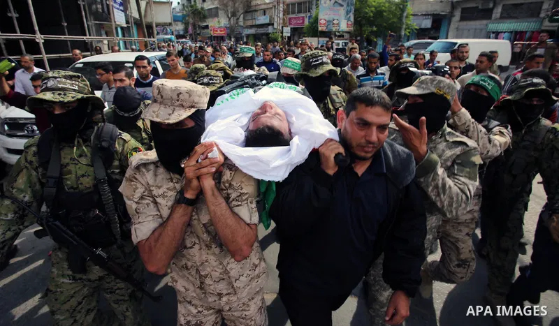 Palestinian mourners and fighters from the Ezzedine al-Qassam Brigades, the armed wing of the Palestinian Hamas movement, carry the body of 30-year-old Mosbah Shabir in Khan Yunis, in the southern Gaza Strip, on October...