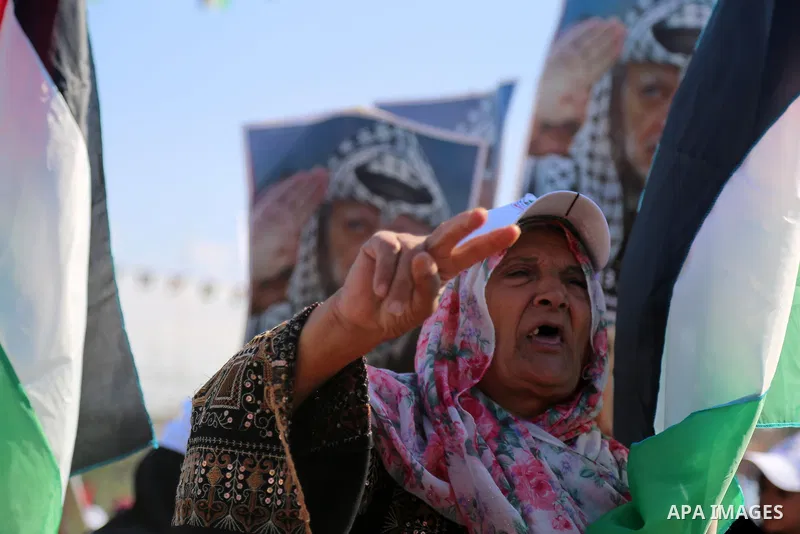 Palestinians hold national flags and posters of the late Palestinian leader Yasser Arafat during a festival to commemorate the 13th anniversary of his death, in Gaza City on November 9, 2017. Photo by Mohammed Dahman