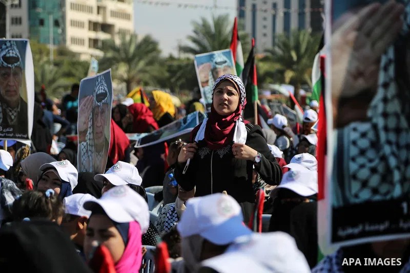 Palestinians hold national flags and posters of the late Palestinian leader Yasser Arafat during a festival to commemorate the 13th anniversary of his death, in Gaza City on November 9, 2017. Photo by Mohammed Dahman