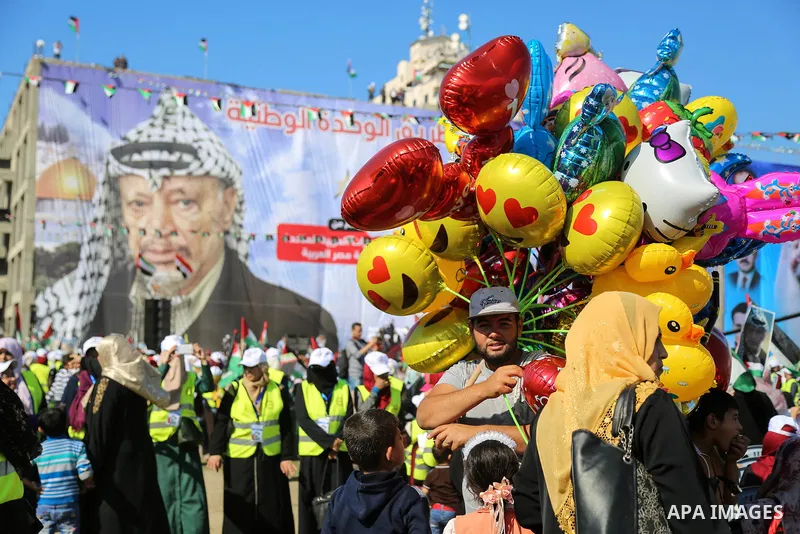 Palestinians hold national flags and posters of the late Palestinian leader Yasser Arafat during a festival to commemorate the 13th anniversary of his death, in Gaza City on November 9, 2017. Photo by Mohammed Dahman
