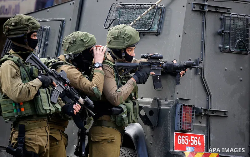 Israeli soldiers stand guard as Israeli settlers walk towards the tomb of Atnaeil Ben Kinaz, a Jewish religious site during an annual pilgrimage organised by Israel's settler movement on the occasion of the Chayei Sarah...