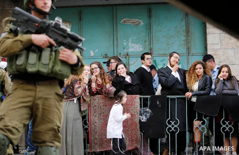 Israeli settlers walk towards the tomb of Atnaeil Ben Kinaz, a Jewish religious site during an annual pilgrimage organised by Israel's settler movement on the occasion of the Chayei Sarah (Life of Sarah) commemorations i...