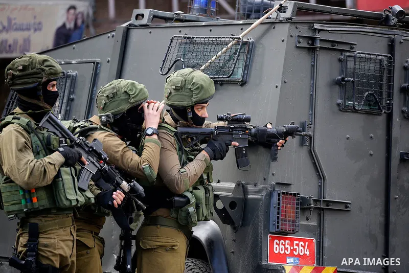 Israeli soldiers stand guard as Israeli settlers walk towards the tomb of Atnaeil Ben Kinaz, a Jewish religious site during an annual pilgrimage organised by Israel's settler movement on the occasion of the Chayei Sarah...