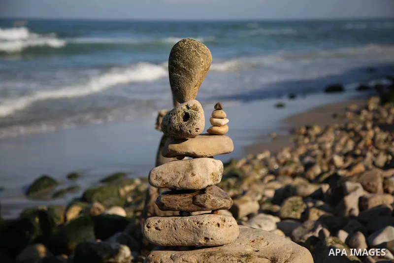A Palestinian youth Ahmed Al Awadi performs rock balancing at the beach of Gaza city on November 16, 2017. Rock balancing is a performance art which involves arranging natural stones usually found on location, in gravity...