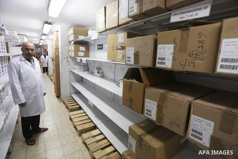 A Palestinian pharmacist stands next shelves which empty from medicines at Al-Shefa Hospital in Gaza City on Nov 16,2017 as Gaza Strip faces a lack of medicines. Photo by Mohammed Asad