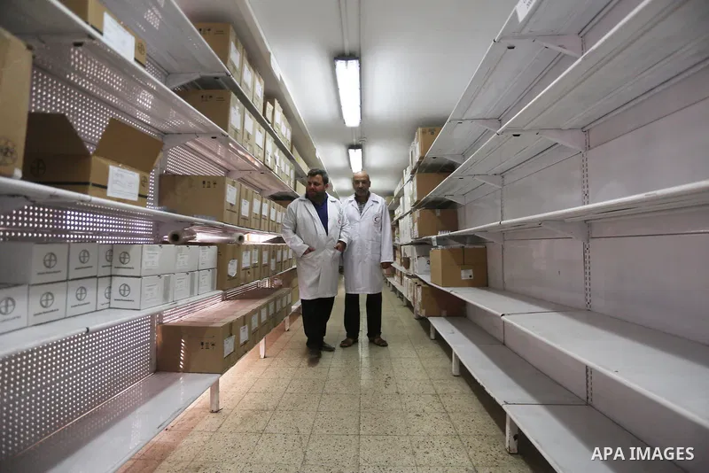 A Palestinian pharmacist stands next shelves which empty from medicines at Al-Shefa Hospital in Gaza City on Nov 16,2017 as Gaza Strip faces a lack of medicines. Photo by Mohammed Asad