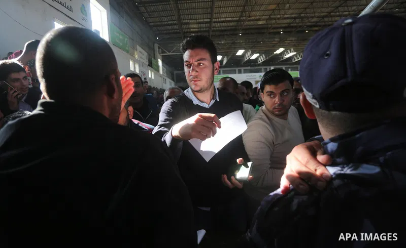 Palestinians wait for travel permits to cross into Egypt, after Rafah border crossing was opened under control of the Western-backed Palestinian Authority for the first time since 2007, in Khan Younis in the southern Gaz...