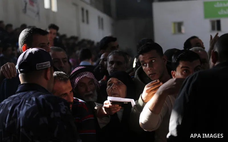 Palestinians wait for travel permits to cross into Egypt, after Rafah border crossing was opened under control of the Western-backed Palestinian Authority for the first time since 2007, in Khan Younis in the southern Gaz...