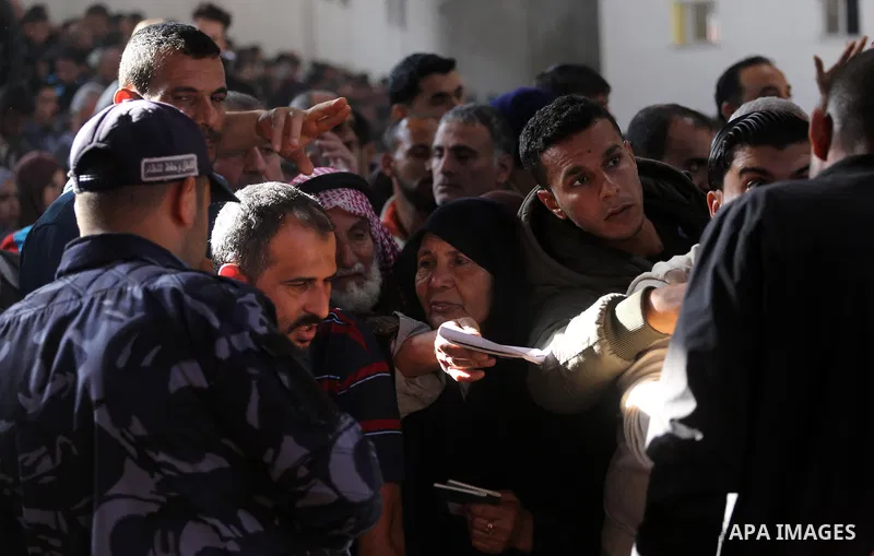 Palestinians wait for travel permits to cross into Egypt, after Rafah border crossing was opened under control of the Western-backed Palestinian Authority for the first time since 2007, in Khan Younis in the southern Gaz...