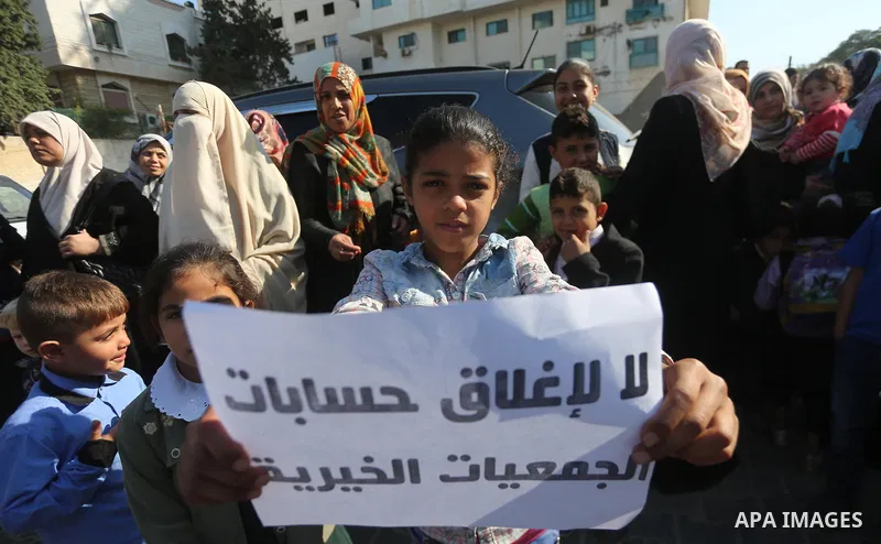 Palestinian orphans take part in a protest against the closure of the accounts of charities in Gaza city, on November 26, 2017. Photo by Mohammed Asad