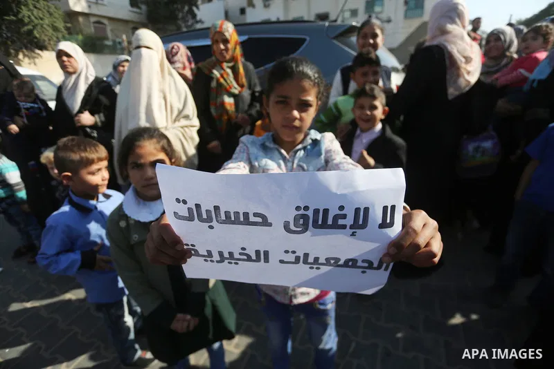 Palestinian orphans take part in a protest against the closure of the accounts of charities in Gaza city, on November 26, 2017. Photo by Mohammed Asad