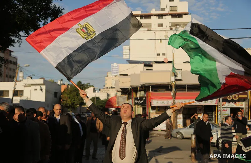 A Palestinian man waves the Palestinian and the Egyptian flag in in a mourning tent set up for people to pay their respects to the Egyptian victims after the deadly attack on a mosque in Egypt's Sinai, on November 26, 20...
