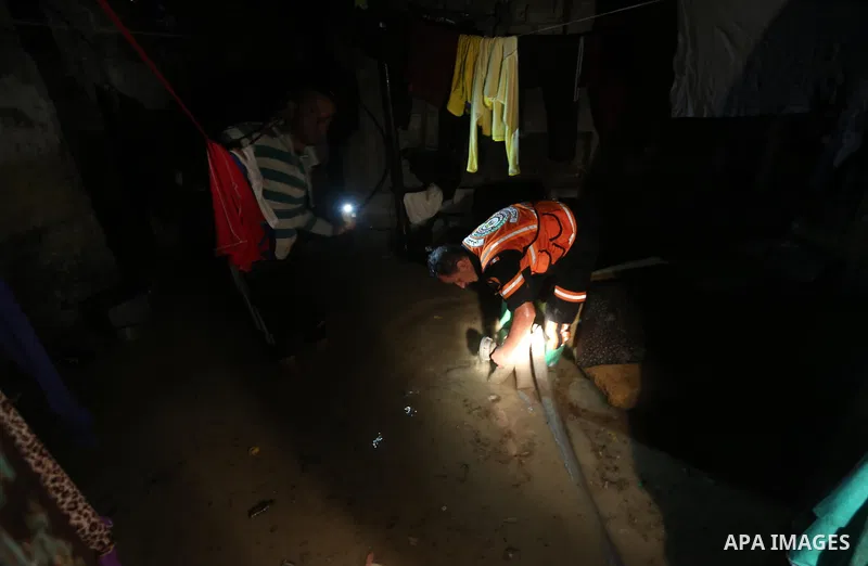 Members of Palestinian Civil Defence work in a flooded street with sewage during a winter storm in Gaza City, on November 27, 2017. Photo by Mohammed Asad