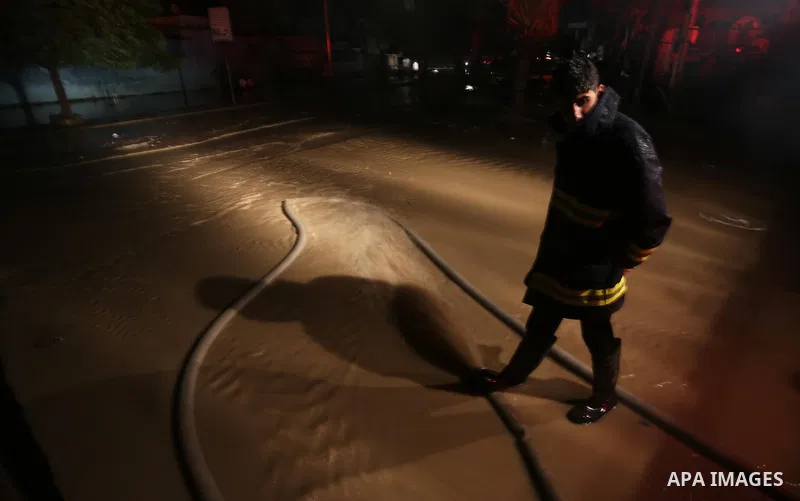 Members of Palestinian Civil Defence work in a flooded street with sewage during a winter storm in Gaza City, on November 27, 2017. Photo by Mohammed Asad