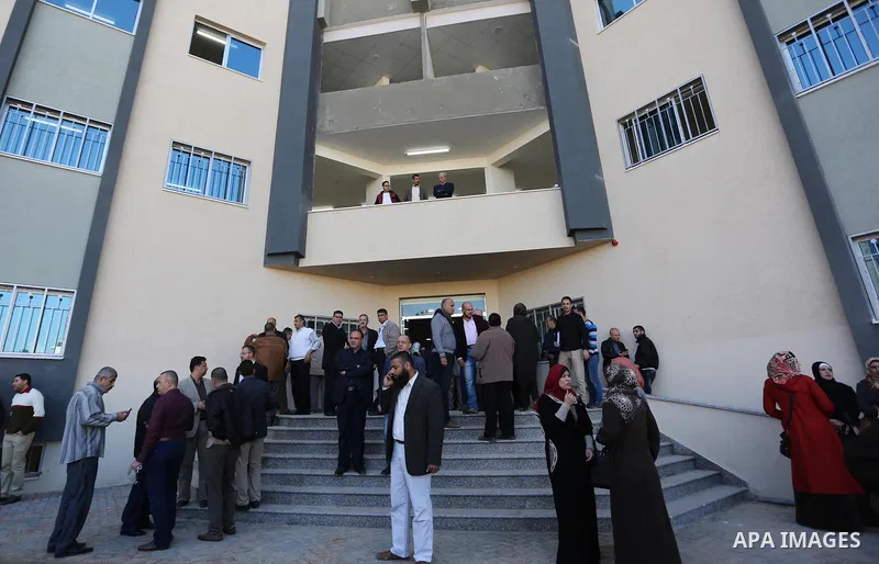 The Palestinian Authority employees, gather as they return to their offices in the headquarters of government ministries in the Gaza Strip in Gaza city on November 29, 2017. The Palestinian Authority began assuming power...