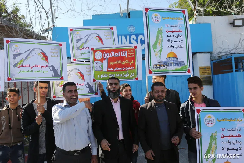 Palestinians hold placards during a protest to mark the anniversary of the decision to partition Palestine outside the UNESCO headquarters on November 29, 2017, in Gaza city. On Nov. 29, 1947, the United Nations General...
