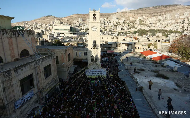 Worshipers sing and dance during a ceremony to commemorate the birth of the Prophet Mohamed in the West Bank city of Nablus, on Nov. 30, 2017. Photo by STR