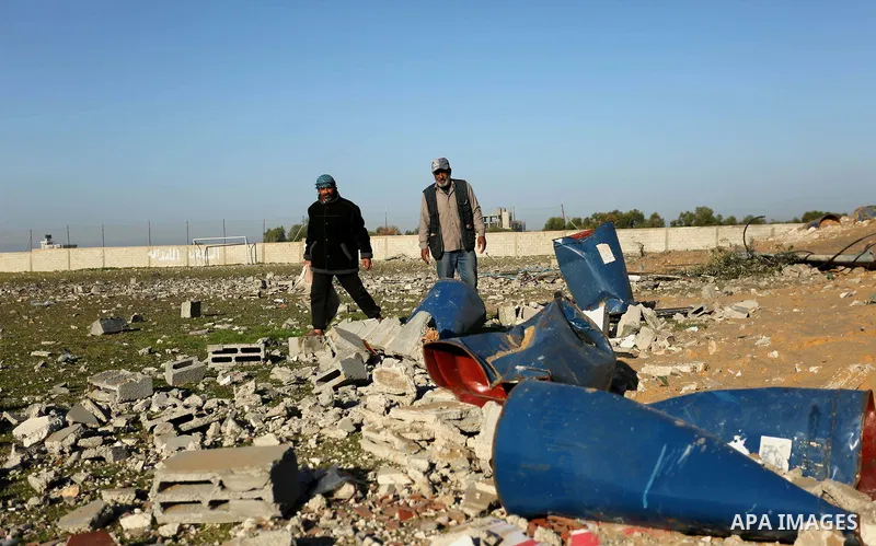 Palestinian men inspect the damage to a soccer field post after it was hit by an Israeli airstrike, on the outskirts of Gaza City December 1, 2017. Photo by Ashraf Amra