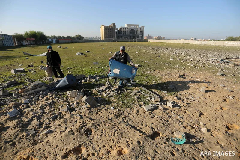 Palestinian men inspect the damage to a soccer field post after it was hit by an Israeli airstrike, on the outskirts of Gaza City December 1, 2017. Photo by Ashraf Amra