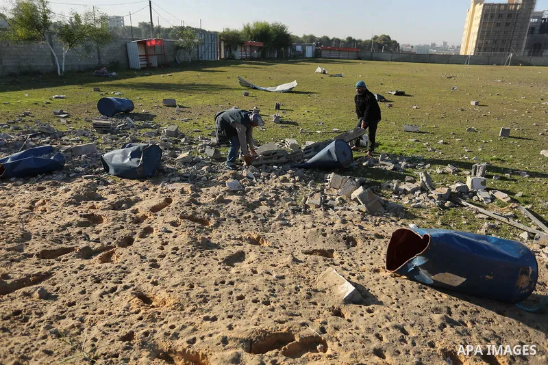 Palestinian men inspect the damage to a soccer field post after it was hit by an Israeli airstrike, on the outskirts of Gaza City December 1, 2017. Photo by Ashraf Amra
