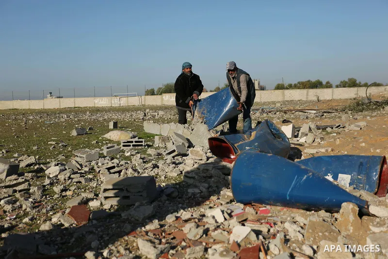 Palestinian men inspect the damage to a soccer field post after it was hit by an Israeli airstrike, on the outskirts of Gaza City December 1, 2017. Photo by Ashraf Amra