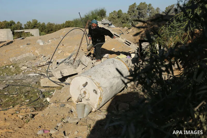 Palestinian men inspect the damage to a soccer field post after it was hit by an Israeli airstrike, on the outskirts of Gaza City December 1, 2017. Photo by Ashraf Amra