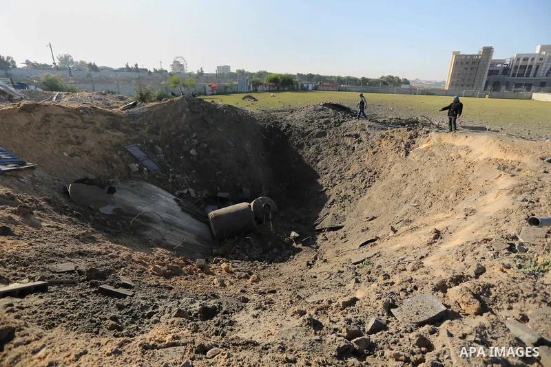 Palestinian men inspect the damage to a soccer field post after it was hit by an Israeli airstrike, on the outskirts of Gaza City December 1, 2017. Photo by Ashraf Amra